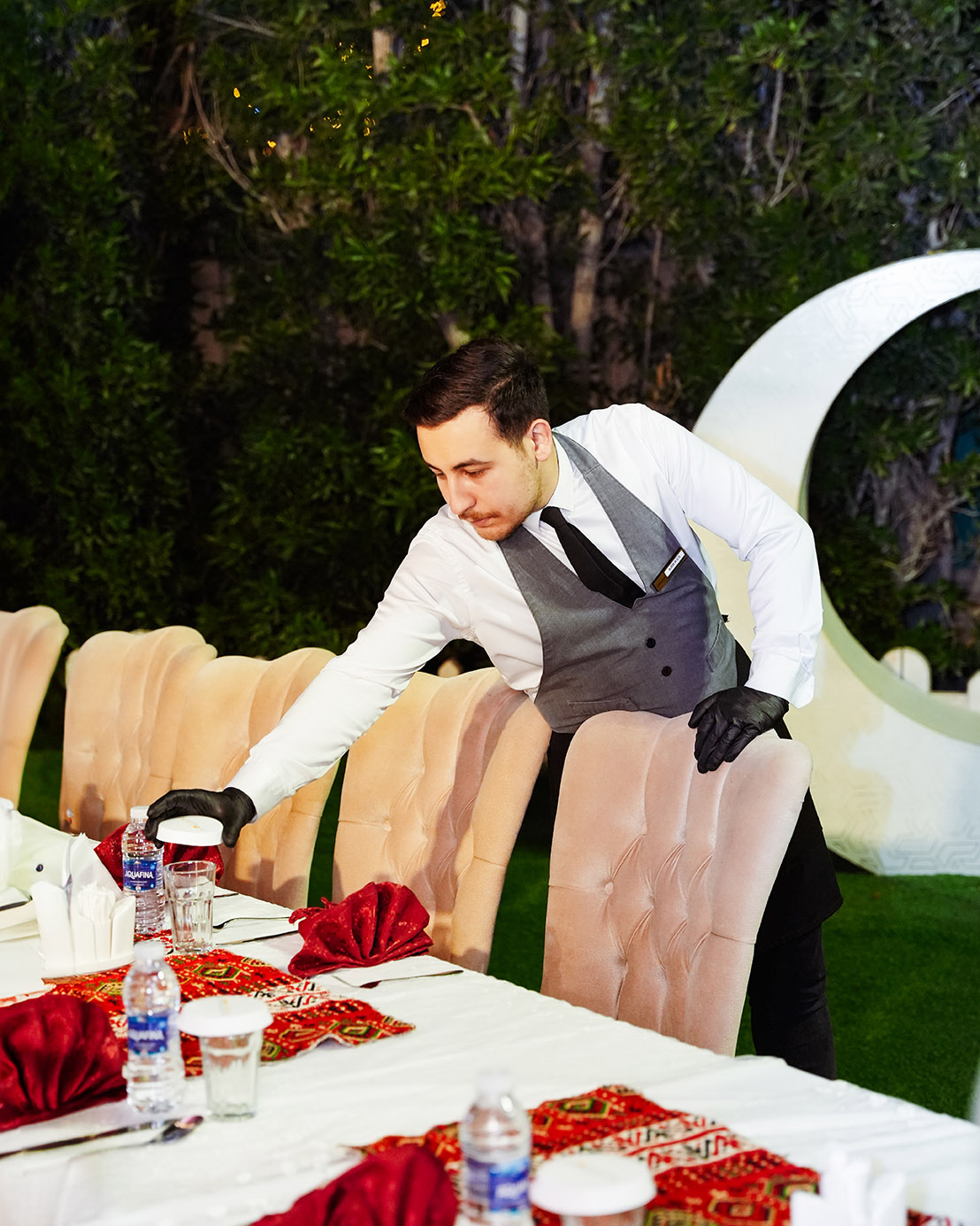 An outdoor evening event with a beautifully lit gazebo and dining tables.